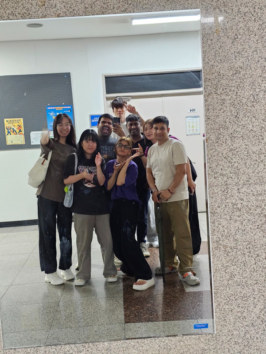 Lab members posing together in a hallway mirror